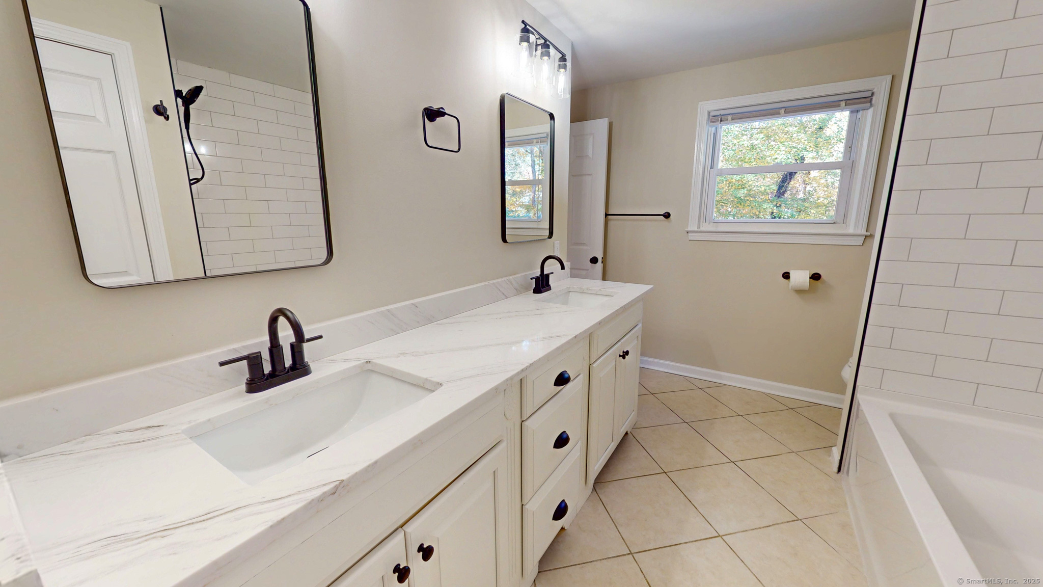 9 Old Farms Road Madison, CT 06443 - Photo 14 of 36 a bathroom with a double vanity sink a mirror and a bathtub