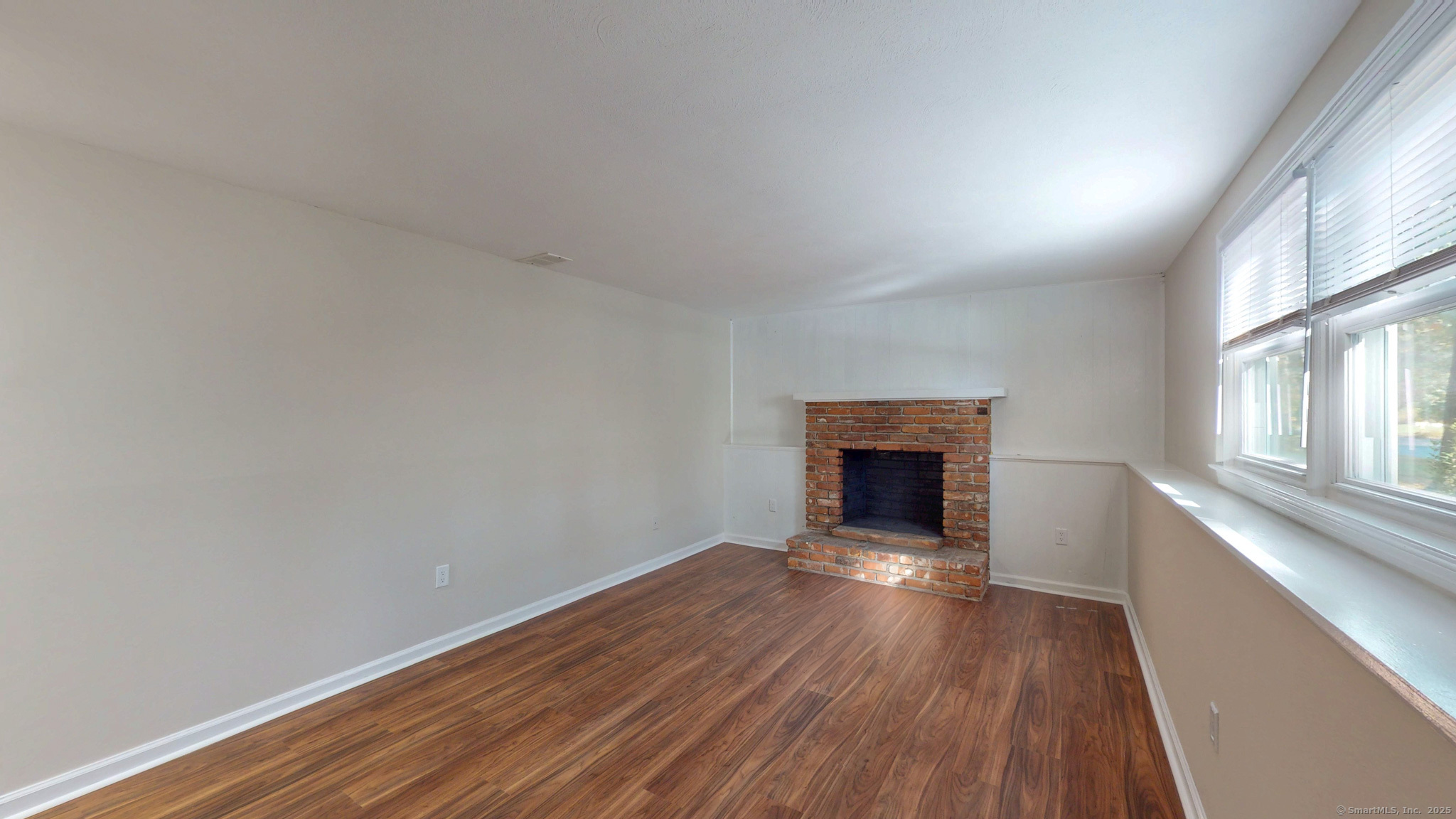 9 Old Farms Road Madison, CT 06443 - Photo 24 of 36 a view of an empty room with wooden floor fireplace and a window