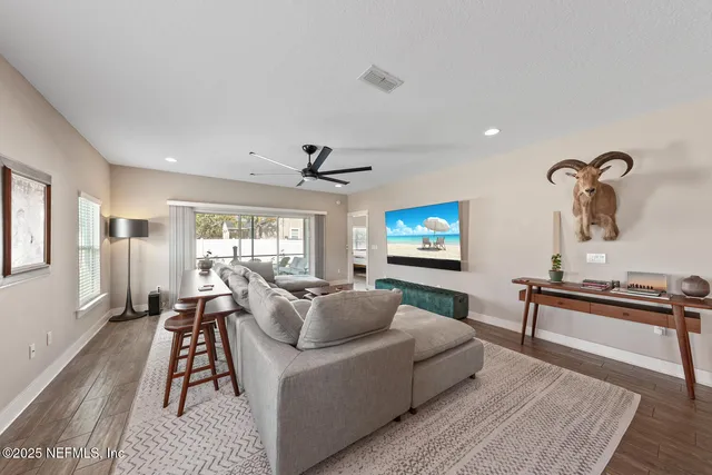 a living room with furniture a flat screen tv and a large window