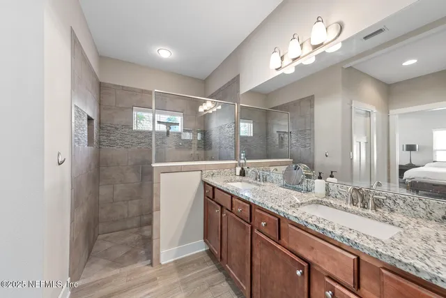 a bathroom with double vanity sinks and a shower