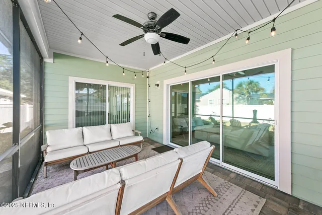 a living room with furniture and a floor to ceiling window