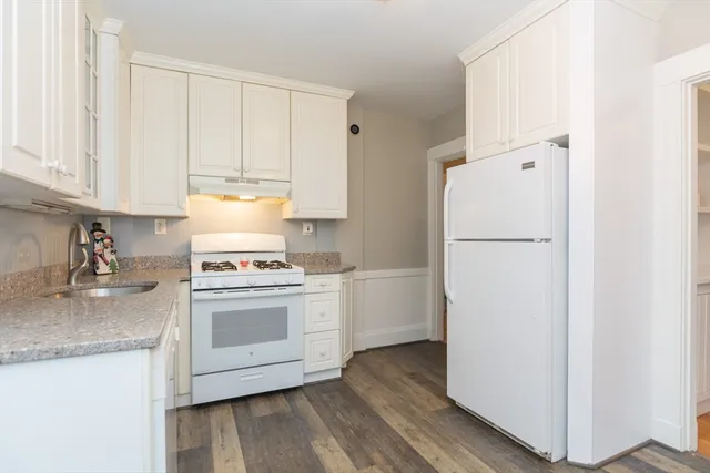a kitchen with a refrigerator sink and cabinets