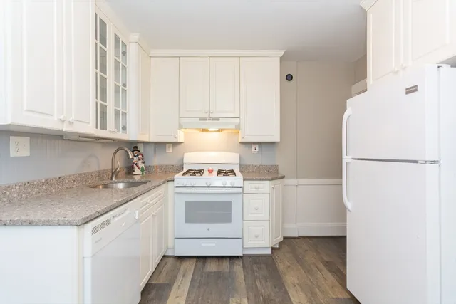 a kitchen with a sink a stove a refrigerator and cabinets