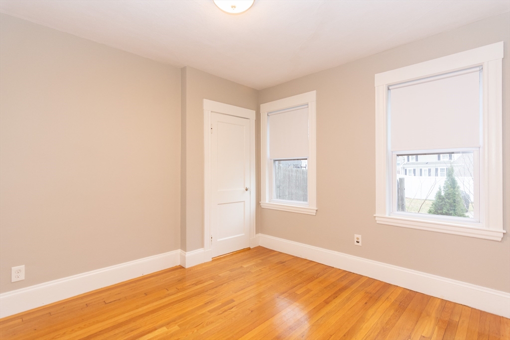 39 Gould Street, Unit A Wakefield, MA 01880 - Photo 22 of 32 a view of an empty room with wooden floor and a window