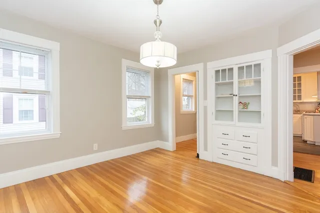 a view of a bedroom with wooden floor and windows