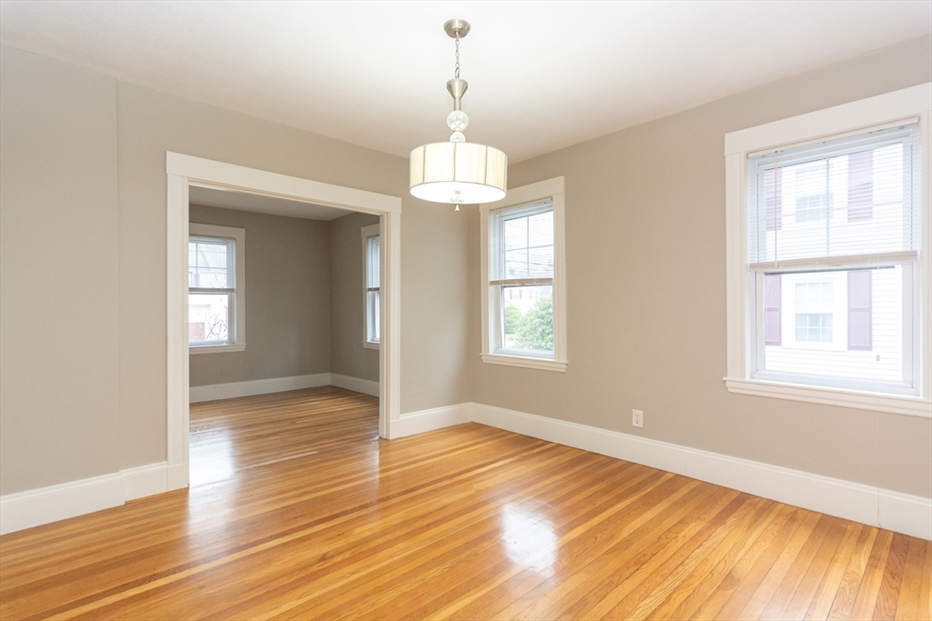 39 Gould Street, Unit A Wakefield, MA 01880 - Photo 6 of 32 a view of an empty room with wooden floor and a window