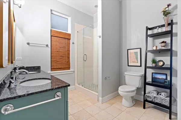 a bathroom with a granite countertop toilet sink and mirror