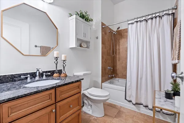 a bathroom with a granite countertop sink toilet a mirror and shower