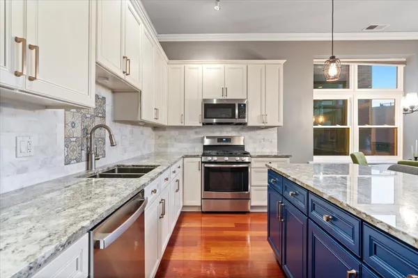 a kitchen with stainless steel appliances granite countertop a sink stove and refrigerator