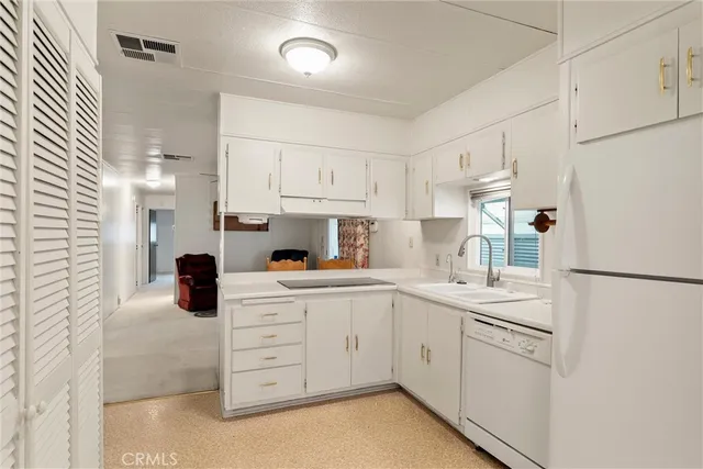 a kitchen with white cabinets and white appliances