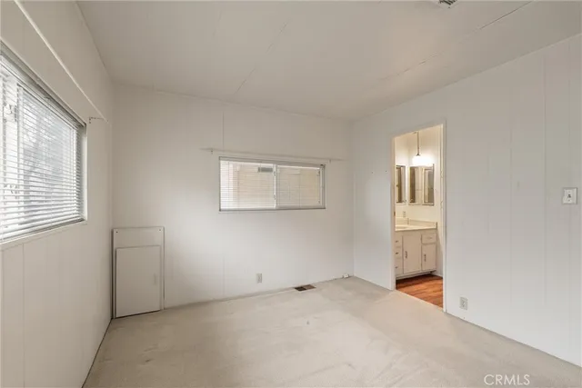 an empty room with windows and closet