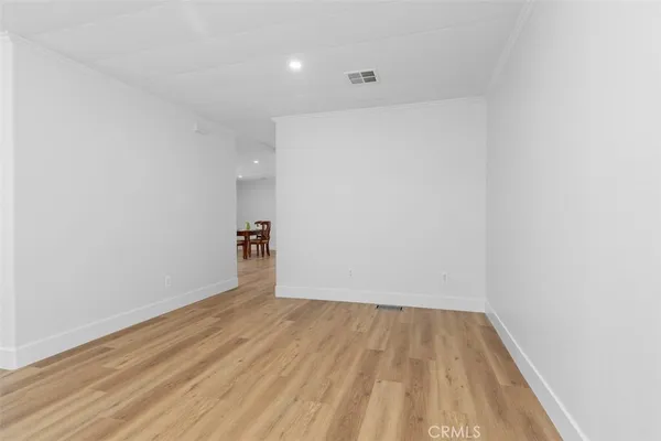 a view of a room with wooden floor and a ceiling fan