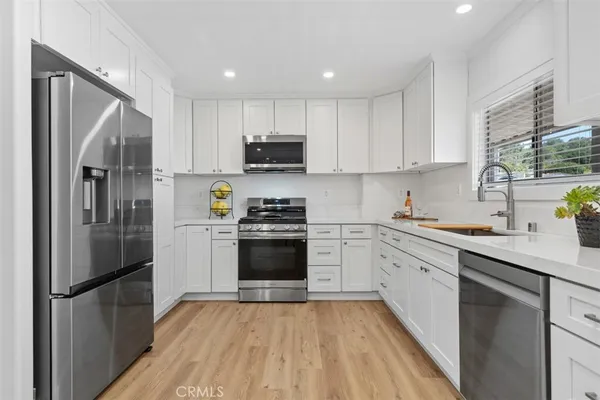 a kitchen with stainless steel appliances a refrigerator stove and sink