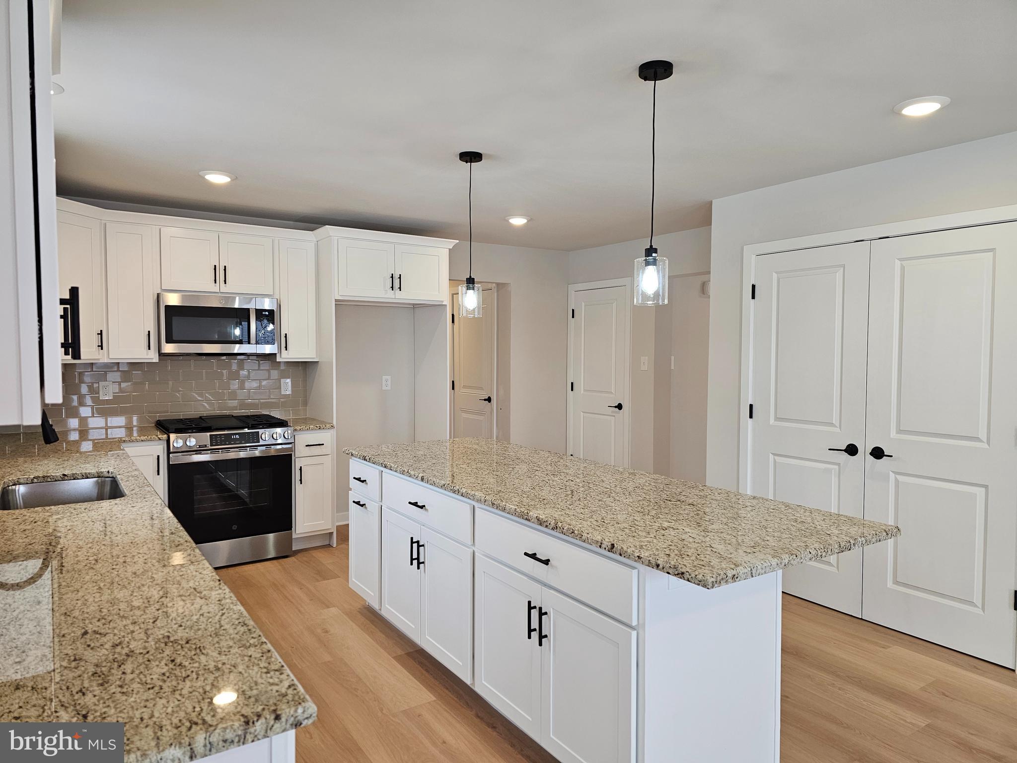 10 Fieldstone Court Bridgeton, NJ 08302 - Photo 2 of 31 a kitchen with kitchen island granite countertop a stove a sink a center island and cabinets