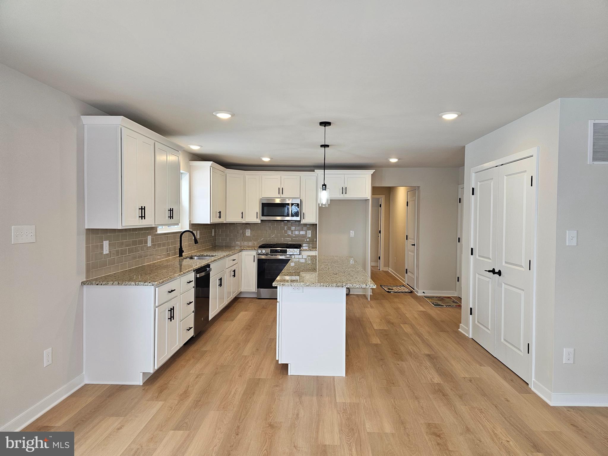 10 Fieldstone Court Bridgeton, NJ 08302 - Photo 3 of 31 a large kitchen with a center island wooden floor stainless steel appliances and cabinets