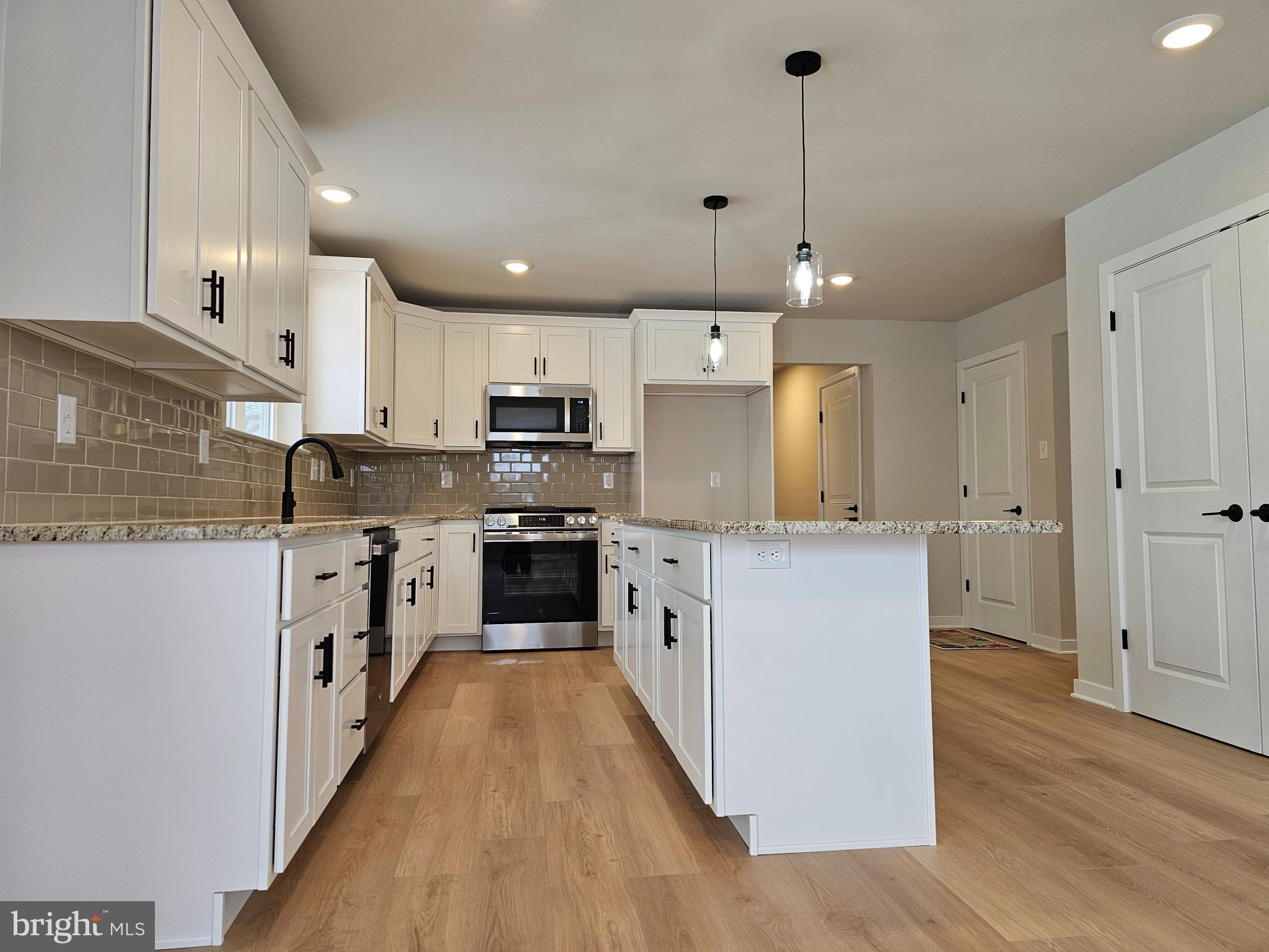 10 Fieldstone Court Bridgeton, NJ 08302 - Photo 4 of 31 a kitchen with kitchen island granite countertop a sink a counter top space stainless steel appliances and cabinets