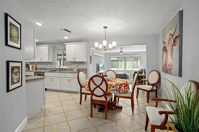 a dining room filled chandelier and kitchen view
