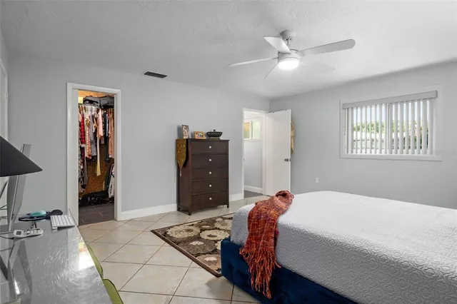 a bed room with a bed and a ceiling fan