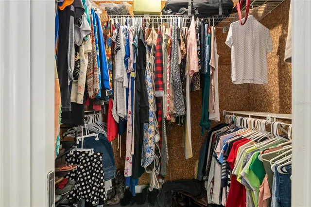 a view of walk in closet with clothes