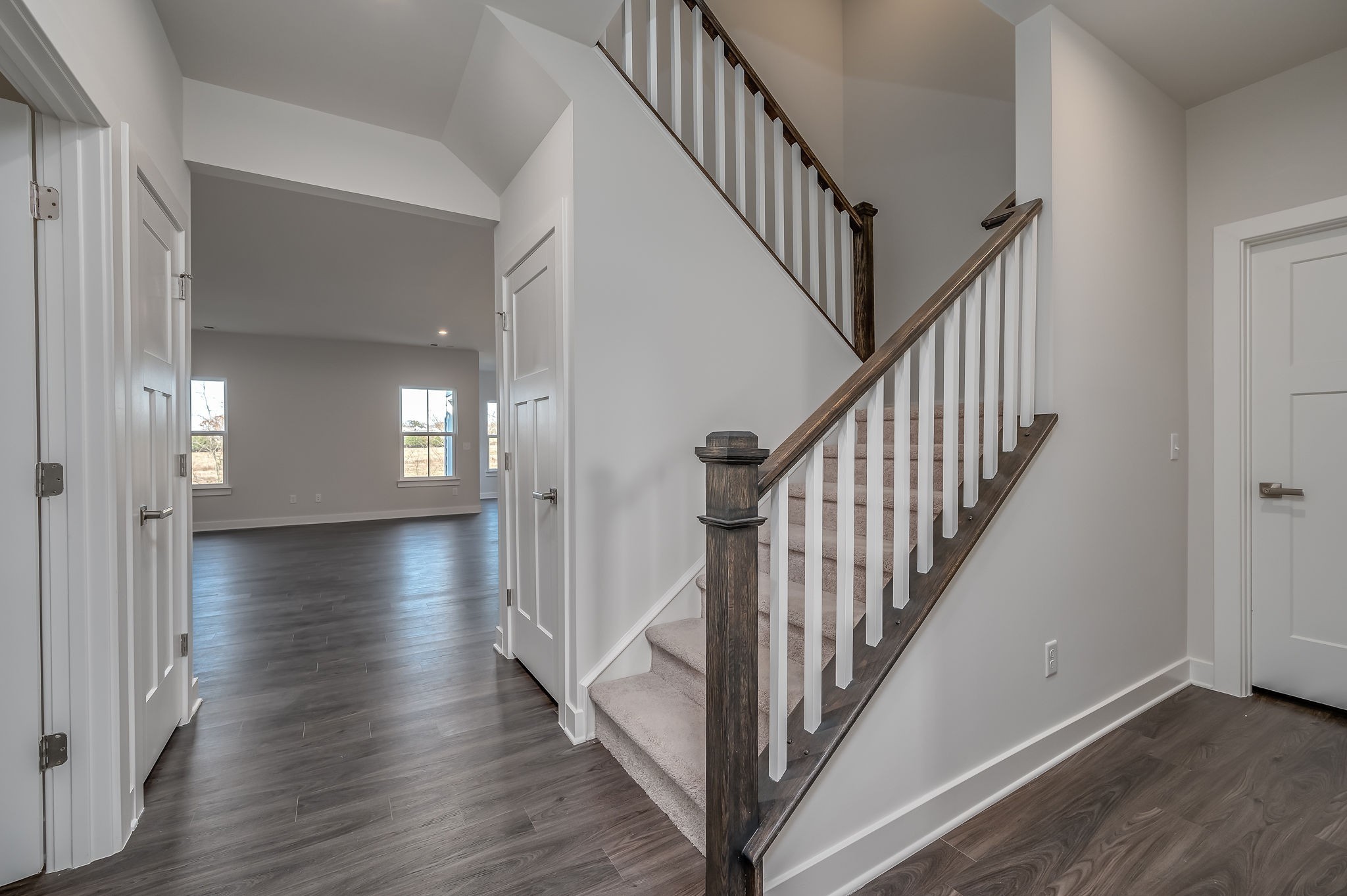 9016 Nestling Ridge College Grove, TN 37046 - Photo 18 of 30 a view of a hallway with wooden floor staircase and a white kitchen