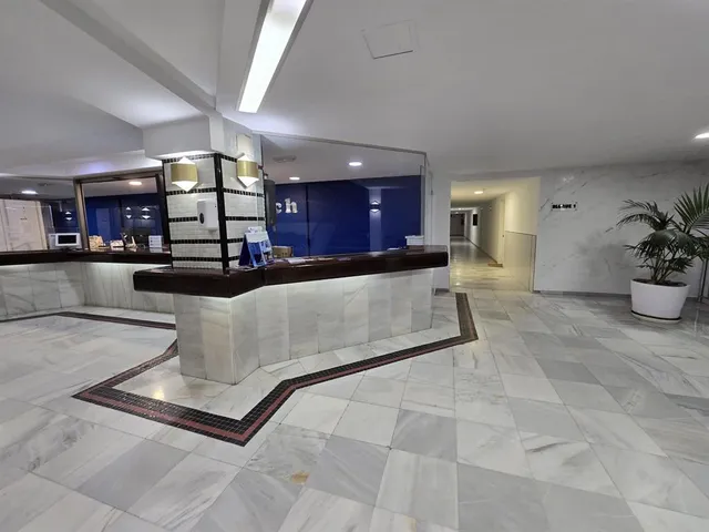a living room with stainless steel appliances lots of white furniture