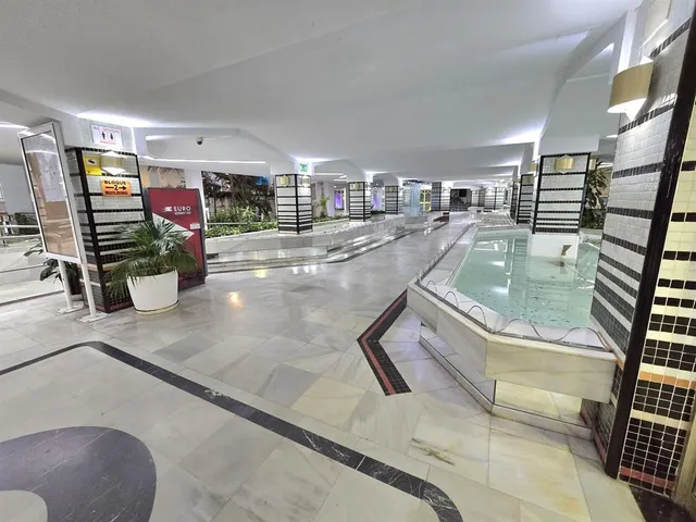 a living room with fireplace furniture and a rug