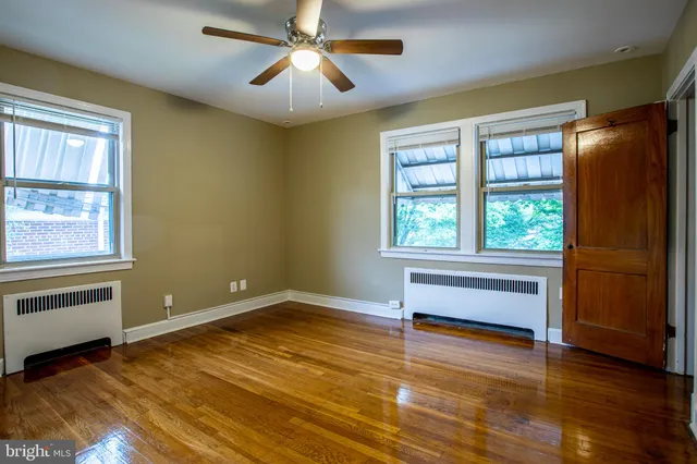 a view of room with window ceiling fan and hardwood floor