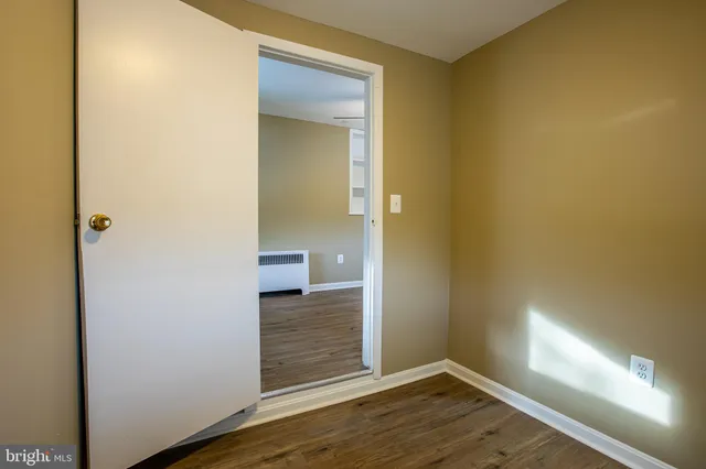 a view of a room with wooden floor and a bathroom