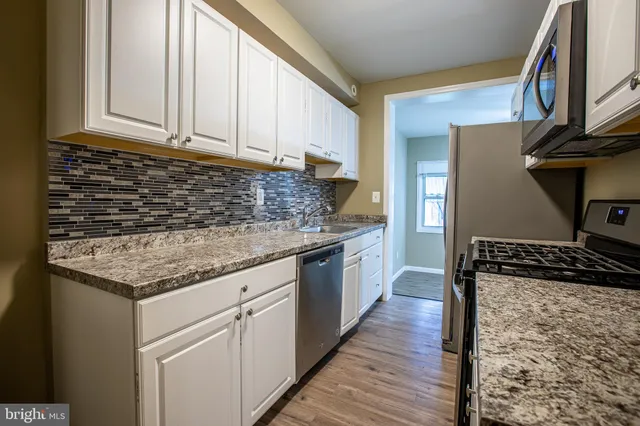 a kitchen with granite countertop a sink and a stove