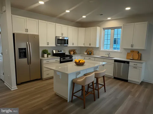 a kitchen with a sink a stove a refrigerator and white cabinets with wooden floor