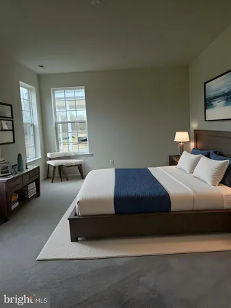 a bedroom with a bed a couch and a flat tv screen on dresser