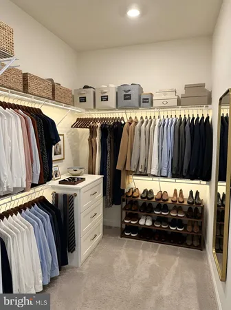 a view of walk in closet with clothes and shoes