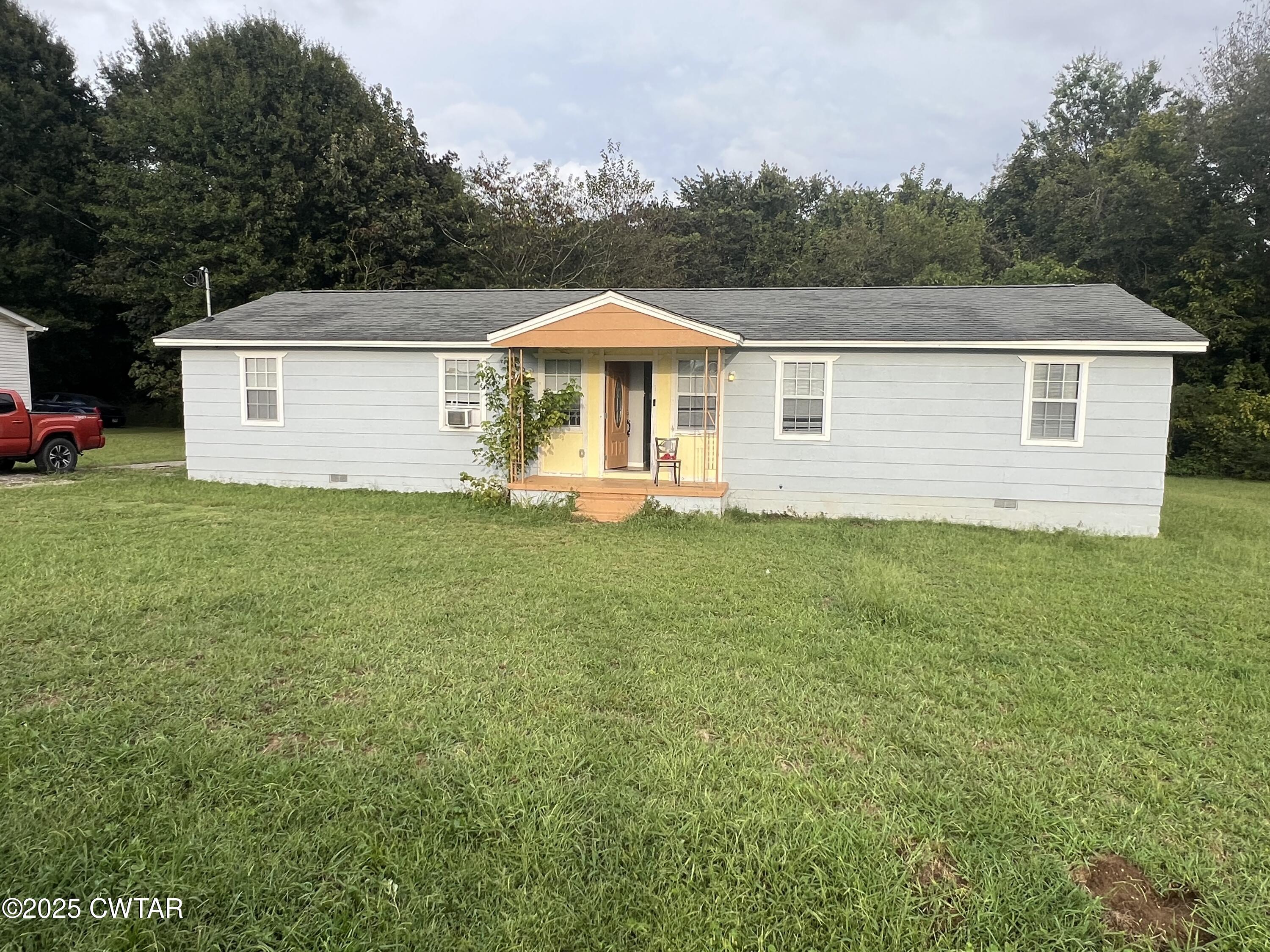 a front view of a house with a yard and trees