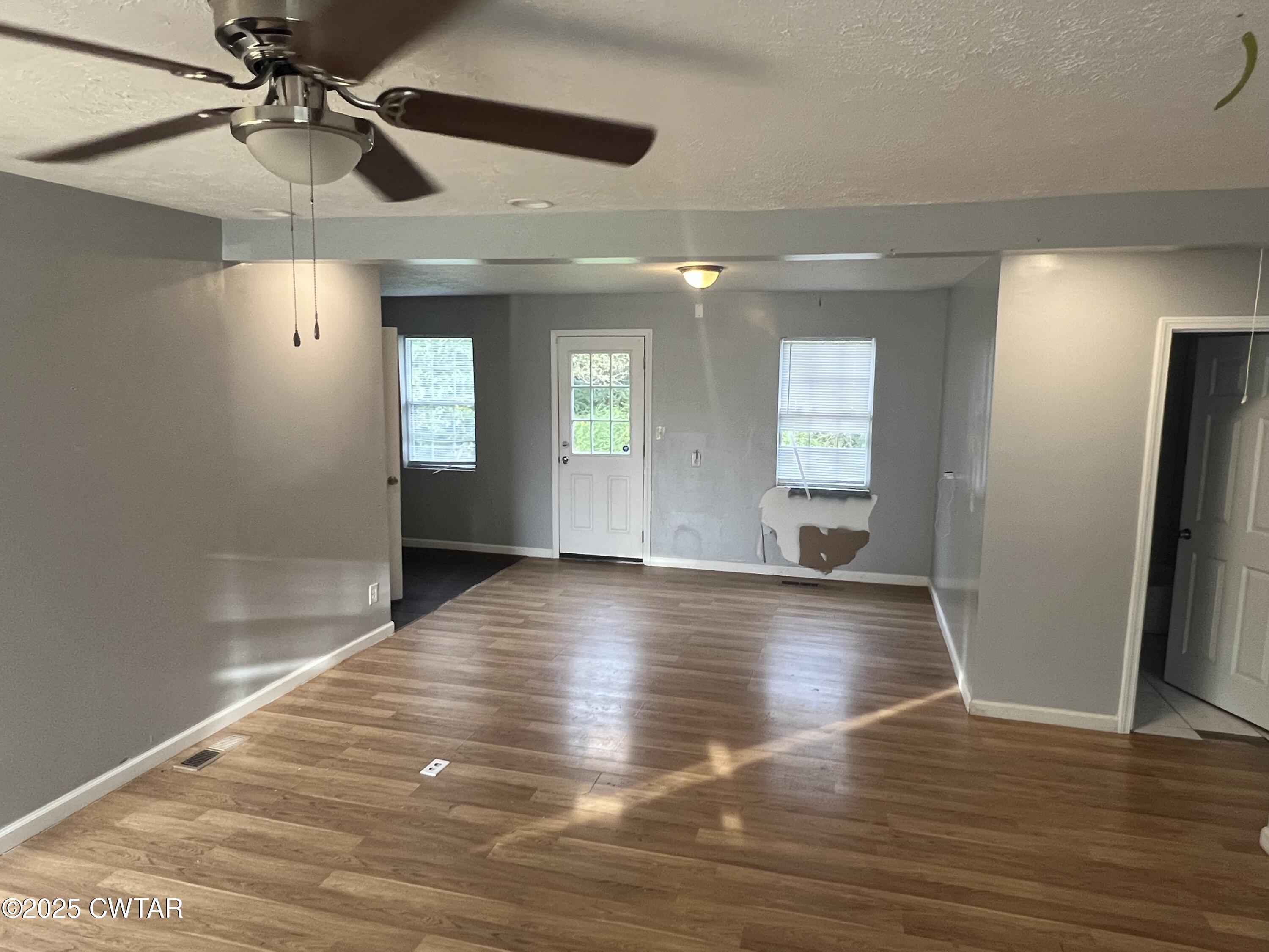 134 Liddon Street Jackson, TN 38301 - Photo 3 of 13 a view of an empty room with window and wooden floor