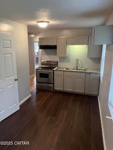 a kitchen with granite countertop cabinets stainless steel appliances and a window