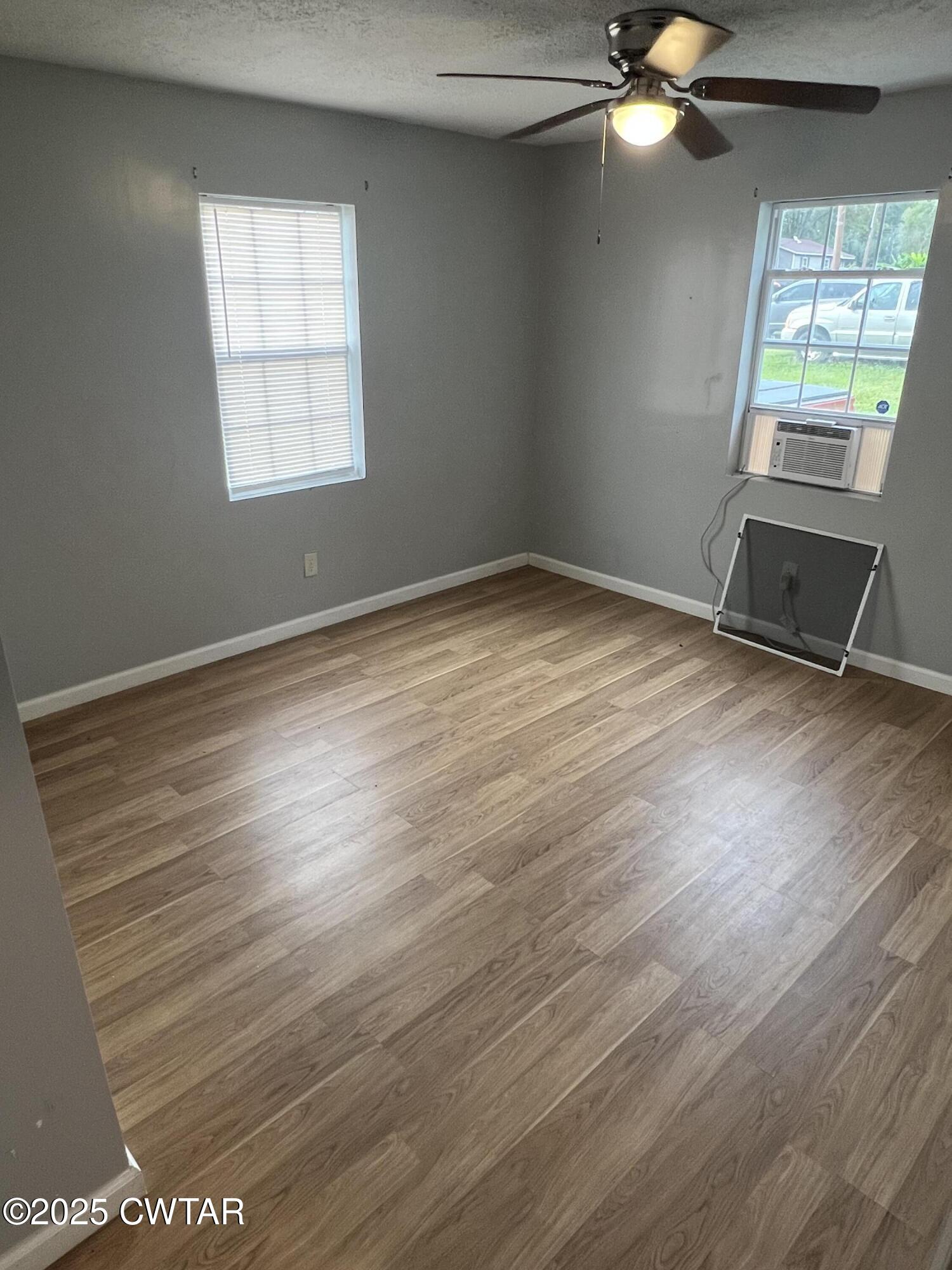 134 Liddon Street Jackson, TN 38301 - Photo 8 of 13 an empty room with wooden floor fan and windows