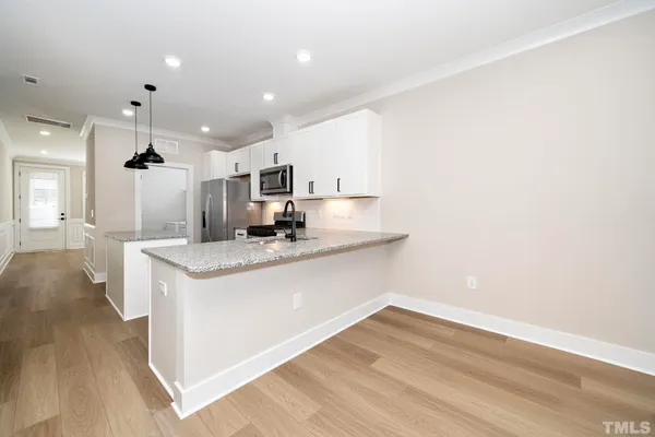 a view of kitchen with granite countertop window and wooden floor