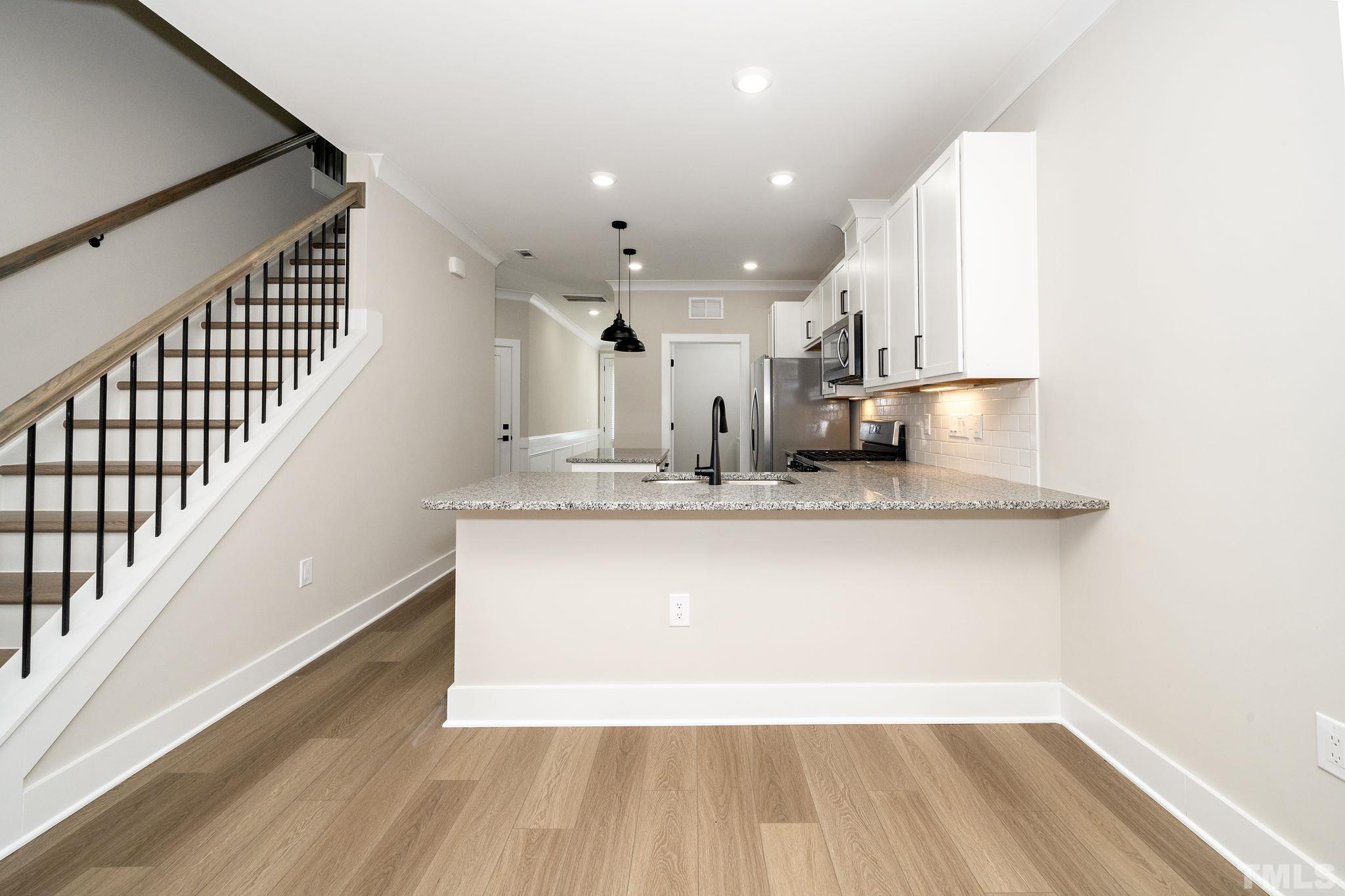 6104 Fox Raleigh, NC 27616 - Photo 14 of 54 a view of kitchen with granite countertop window and wooden floor