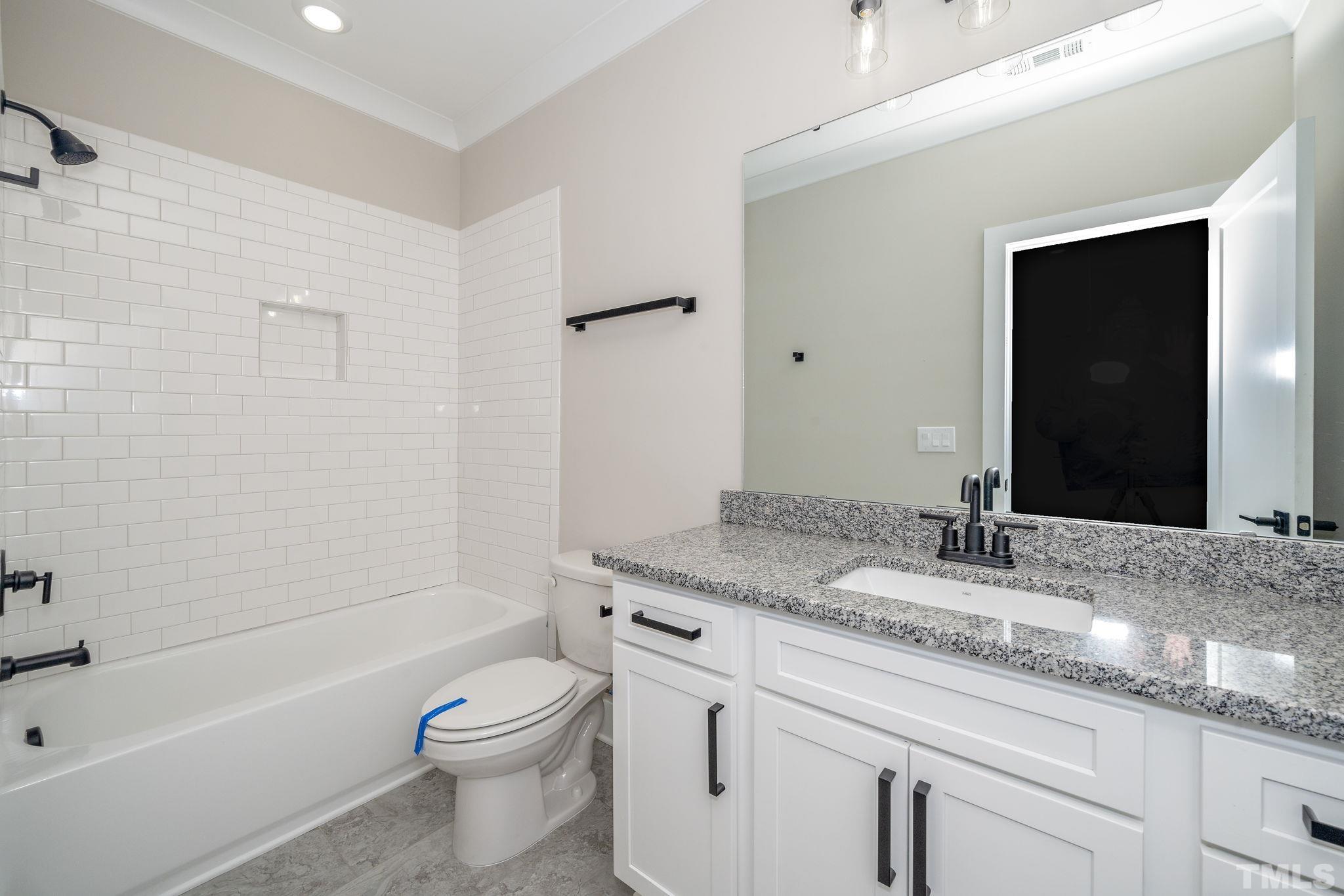 6104 Fox Raleigh, NC 27616 - Photo 20 of 54 a bathroom with a granite countertop sink a toilet and shower