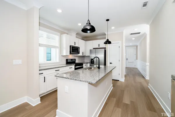 a kitchen with stainless steel appliances granite countertop a sink and a stove top oven