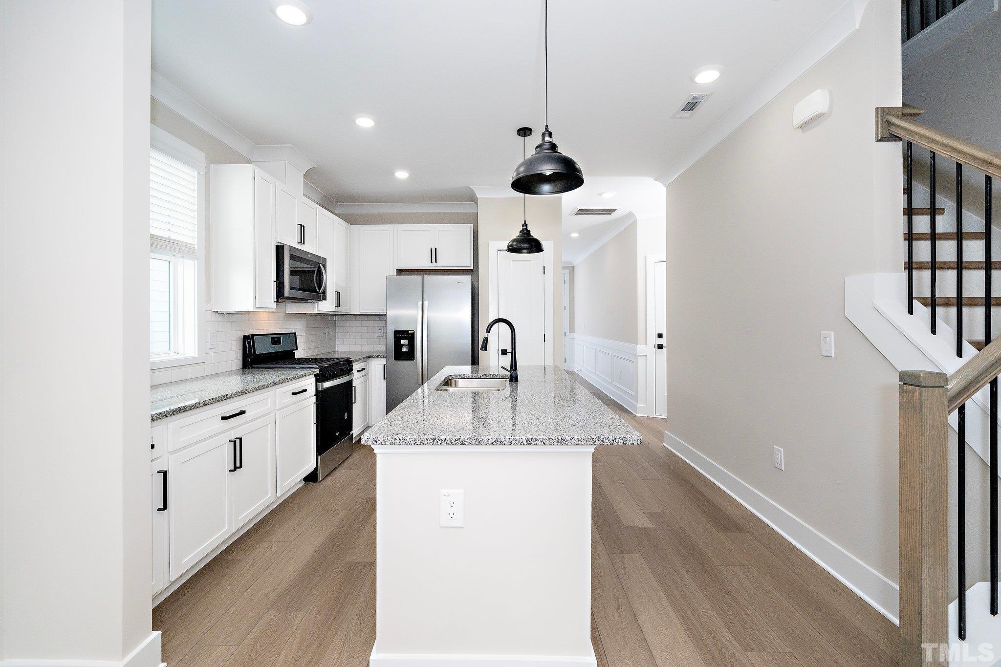 6104 Fox Raleigh, NC 27616 - Photo 37 of 54 a large kitchen with granite countertop a sink stainless steel appliances and cabinets