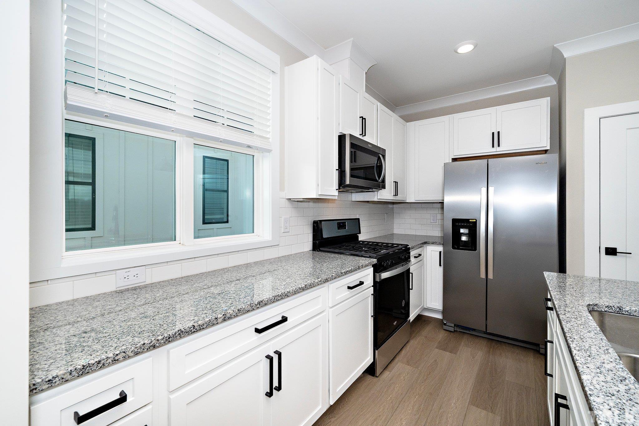 6104 Fox Raleigh, NC 27616 - Photo 39 of 54 a kitchen with stainless steel appliances granite countertop a sink a stove and a refrigerator