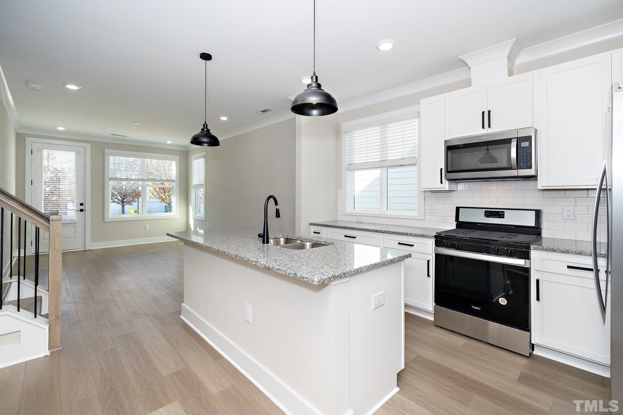 6104 Fox Raleigh, NC 27616 - Photo 40 of 54 a kitchen with stainless steel appliances granite countertop a sink and a stove top oven