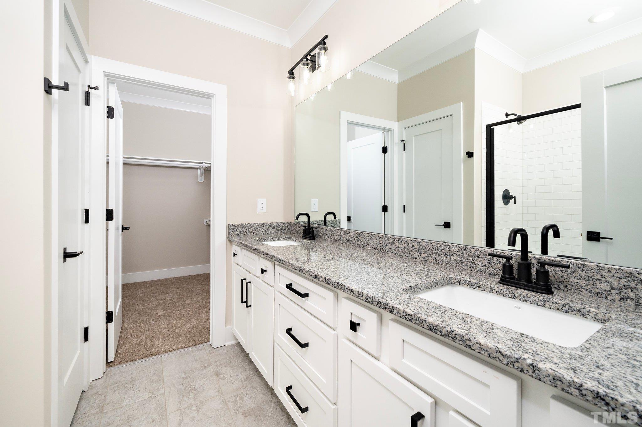 6104 Fox Raleigh, NC 27616 - Photo 45 of 54 a bathroom with a granite countertop double vanity sink shower and a mirror
