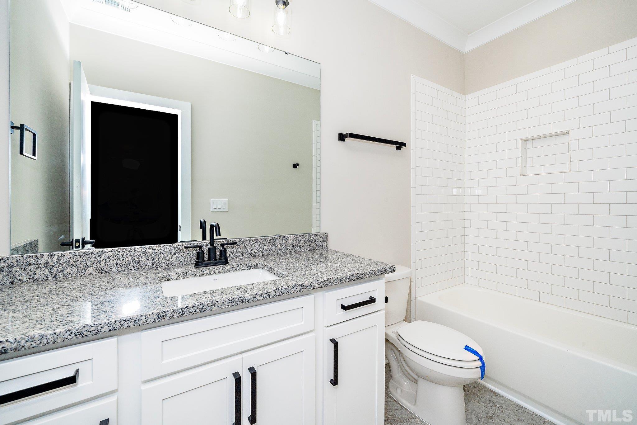 6104 Fox Raleigh, NC 27616 - Photo 50 of 54 a bathroom with a granite countertop sink a toilet and bathtub
