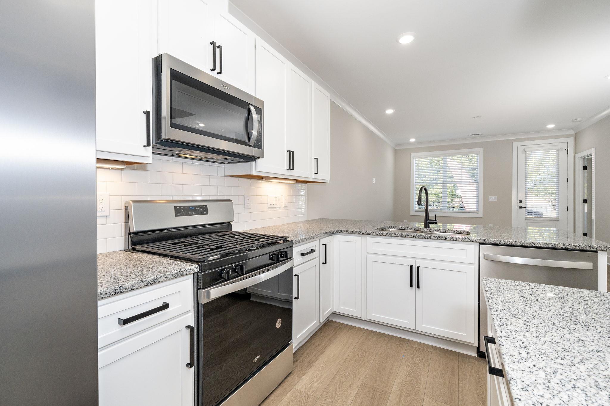 6104 Fox Raleigh, NC 27616 - Photo 10 of 54 a kitchen with stainless steel appliances granite countertop a stove top oven microwave and cabinets