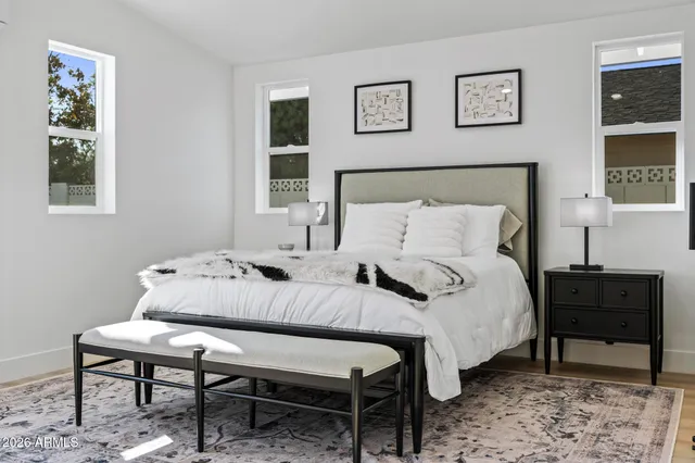 a bedroom with a bed and a lamp on the dresser