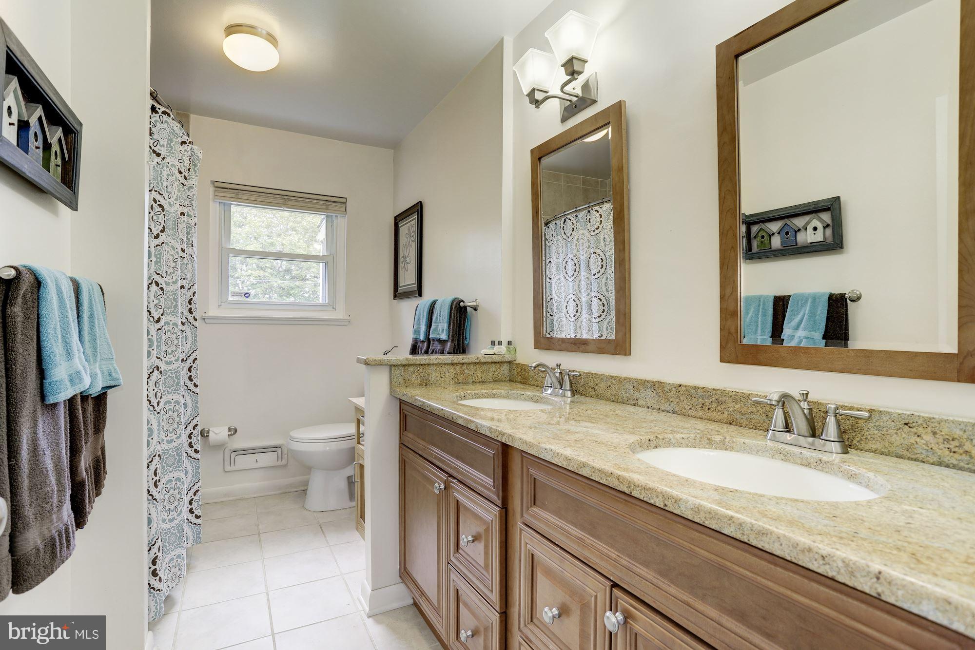 6134 Wheatland Road Baltimore, MD 21228 - Photo 13 of 30 a bathroom with a granite countertop sink toilet and mirror