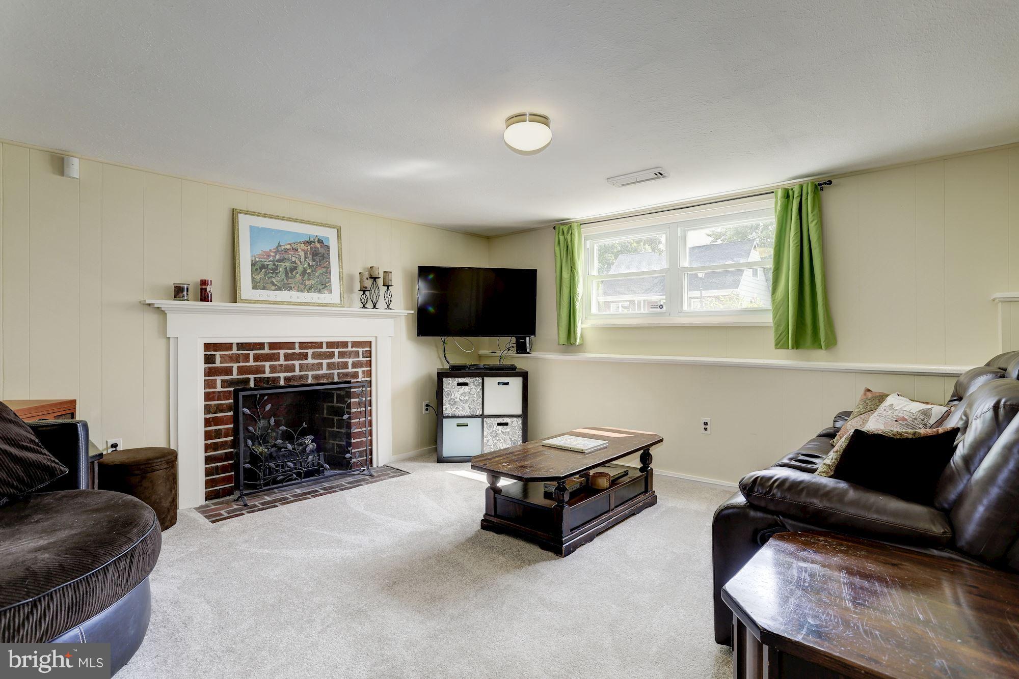 6134 Wheatland Road Baltimore, MD 21228 - Photo 20 of 30 a living room with furniture a fireplace and a flat screen tv