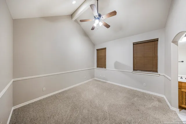 a view of an empty room with chandelier fan
